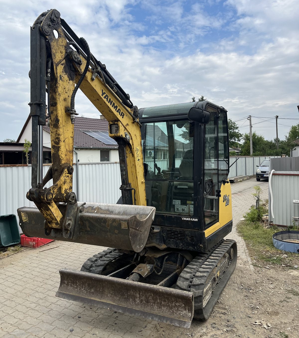 Yanmar SV26 minikotró tolólappal, két kerítés közötti szűk átjáróban Nyírpazonyban